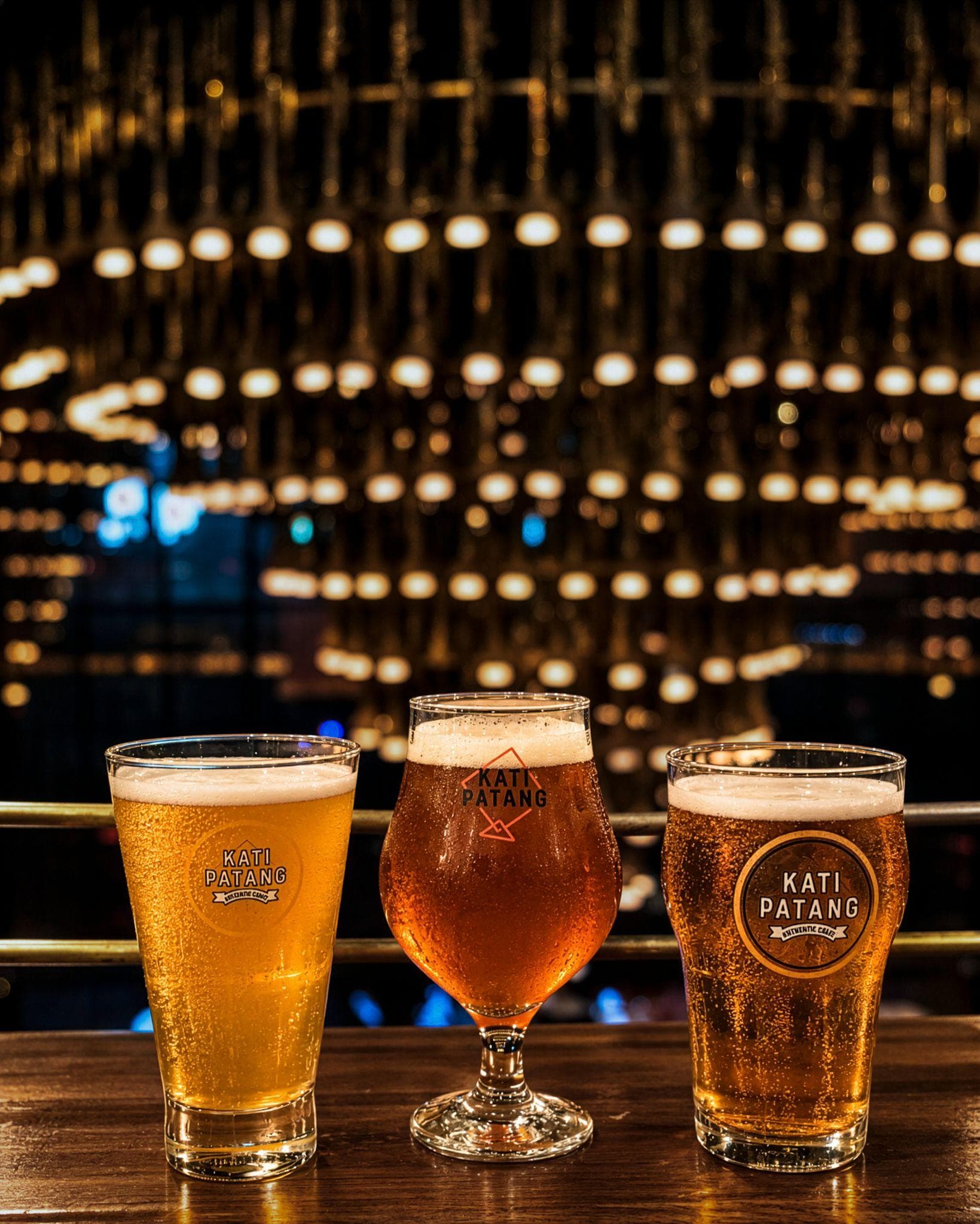 Three Kati Patang beers served in different glass styles at a bar