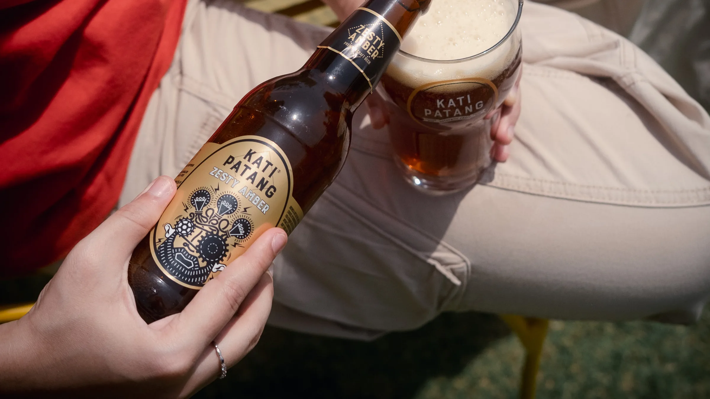 A bottle of Kati Patang Zesty Amber beside a glass of beer